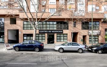 Oficina en alquiler en Madrid, Calle López de Aranda 35, mostrando una fachada de ladrillo con ventanas amplias y letrero de 'CENTRO DE NEGOCIOS'.
