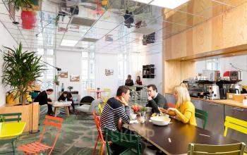 Vibrant office space rental at Rue de la République 113, Marseille 2, with professionals engaging in discussions and casual meetings.