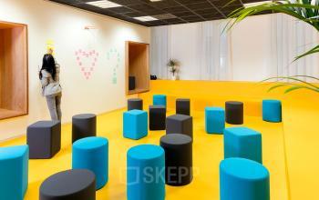Modern office space rental at Rue de la République 113 in Marseille 2 featuring colorful furniture and a person engaged in a task.