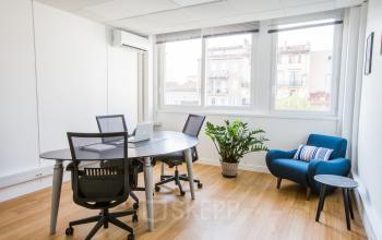 Espace de bureau à louer lumineux et meublé Avenue du Prado 24, dans Marseille 8ème, avec plancher en bois, plantes et vue sur la ville.