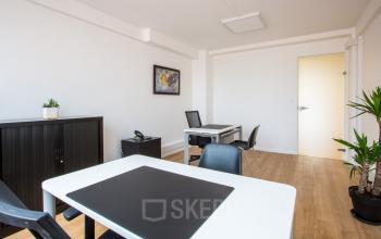 Intérieur épuré d'un espace de bureau à louer Avenue du Prado 24, Marseille 8ème, avec bureau blanc, chaises et plantes décoratives.