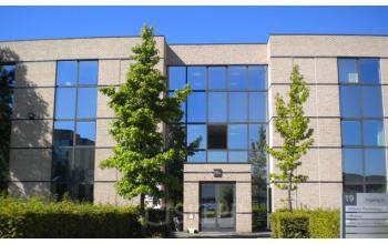 Exterior view of the office building at Generaal de Wittelaan 11a, Mechelen North. Modern facade with large windows and green landscaping, ideal for office space rental.