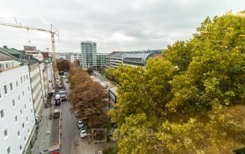 Street view of Herzogspitalstraße in Munich Old Town, showcasing surrounding buildings and trees. Ideal for office space rental.