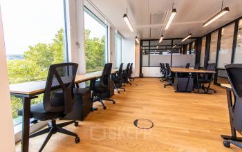 Spacious and modern office space with large windows and ergonomic chairs, ideal for rental in Munich Old Town.