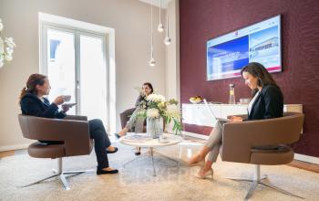 Büroraum in der Maximilianstraße 2 in München Altstadt, drei Personen bei geschäftlichen Aktivitäten im modern möblierten Büro.