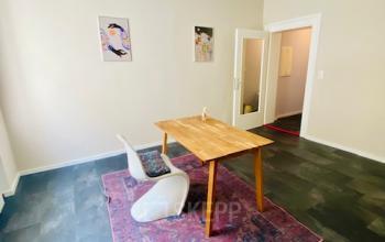 Gemütlicher Büroraum mit Holztisch und Stühlen in der Thierschstr 33, München Altstadt. Bürofläche mieten.