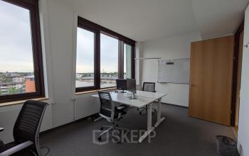 Bright office space rental at Christoph-Rapparini-Bogen 25 in Munich Laim, featuring large windows, desks, chairs, and a whiteboard.