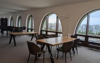 Interior of office space rental at Christoph-Rapparini-Bogen 25, Munich Laim, Munich with large arched windows, modern chairs, and wooden tables.