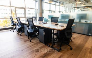 Helles Büro in München Maxvorstadt mit großen Fenstern und modernen Möbeln, ideal zum Büro mieten. Die Bürofläche bietet mehrere Arbeitsplätze mit Schreibtischen und ergonomischen Stühlen.