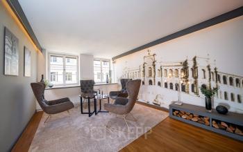 Büroraum in der Ludwigstraße 8, München Maxvorstadt: Modernes Interieur mit stilvollen Sesseln und großem Wandbild, ideal zum Büroraum mieten.