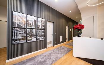 Moderne Büroeingangshalle mit Kunst an der Wand und Blumen am Empfang im Bürogebäude Hopfenstraße 8, München Maxvorstadt. Ideal zum Büroraum mieten.