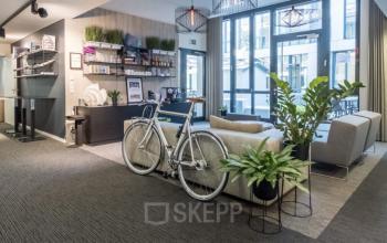 Moderne Bürofläche in der Luise-Ullrich-Straße 20, München Neuhausen, mit stilvollen Möbeln, Pflanzen und einem Fahrrad im Empfangsbereich.