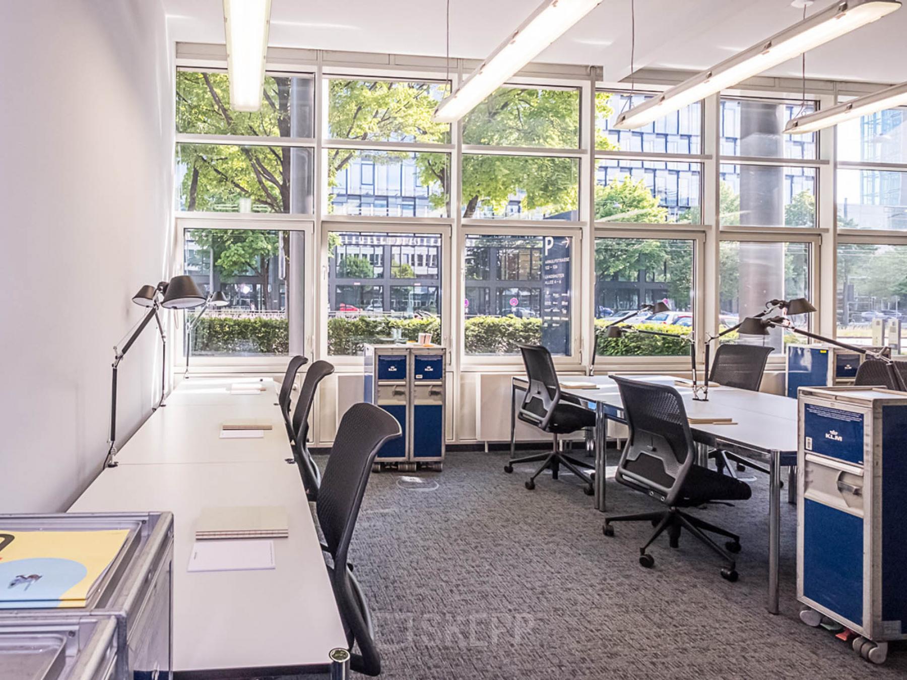 Helle Bürofläche mieten in München Neuhausen, Luise-Ullrich-Straße 20. Großer Arbeitsbereich mit großen Fenstern, modernen Möbeln und Blick auf die Straße.