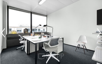 Helles Büro mit weißen Möbeln und großem Fenster