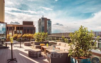 Moderne Terrasse des Bürogebäudes in der Luise-Ullrich-Straße 14 in München Neuhausen mit Sitzgelegenheiten und Pflanzen, ideal zum Entspannen.