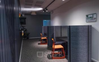 Modernes Büro in Arnulfstraße 122-126, München Neuhausen, mit abgetrennten Arbeitsplätzen und orangenen Stühlen.