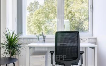 Helles Büro zur Miete im Carl-Zeiss-Ring 15a, München Nord, mit modernem Schreibtisch, Bürostuhl und grüner Aussicht.