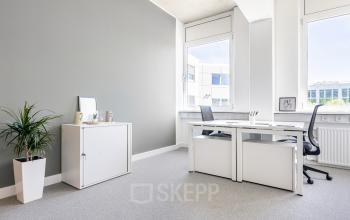 Helles Büro am Carl-Zeiss-Ring 15a in München Nord mit zwei Schreibtischen, Bürostühlen und einer Pflanze in der Ecke.