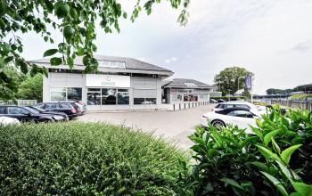 Exterior view of an office building located at Rijksweg 79, Naarden, featuring a parking lot and clear signage for office space rental.