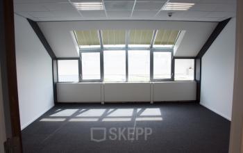 Empty office space with carpet flooring, large windows, and ceiling lights at Rijksweg 79, Naarden, available for office space rental.