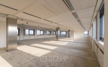 Spacious office interior at Nevelgaarde 8-19, Nieuwegein, featuring large windows and ample natural light, ideal for office space rental.