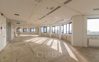 Spacious, unfurnished open floorplan for office space rental at Nevelgaarde 8-19, Nieuwegein, featuring large windows and ample natural light. Ideal for customizing a professional workspace.