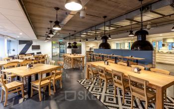 Modern furnished workspace at Zoomstede 13-25 in Nieuwegein with wooden tables, chairs, and industrial decor suitable for office space rental.