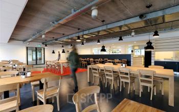 Spacious, modern office space rental with wooden tables and chairs, exposed ceiling, and a casual atmosphere at Zoomstede 13-25, Nieuwegein.
