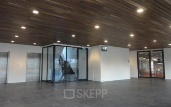 Spacious modern lobby at Zoomstede 13-25 in Nieuwegein, featuring sleek floors, elevator access, and glass-walled staircase area, ideal for an office space rental.