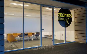 Modern office space rental at Zoomstede 13-25, Nieuwegein, featuring a bright area with chairs and a meeting table.