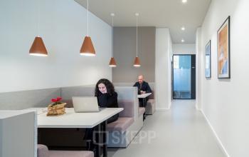 Modern office interior at Oranjesingel 51, Nijmegen, featuring contemporary workspaces with individuals engaged in business activities. Ideal location for office space rental.
