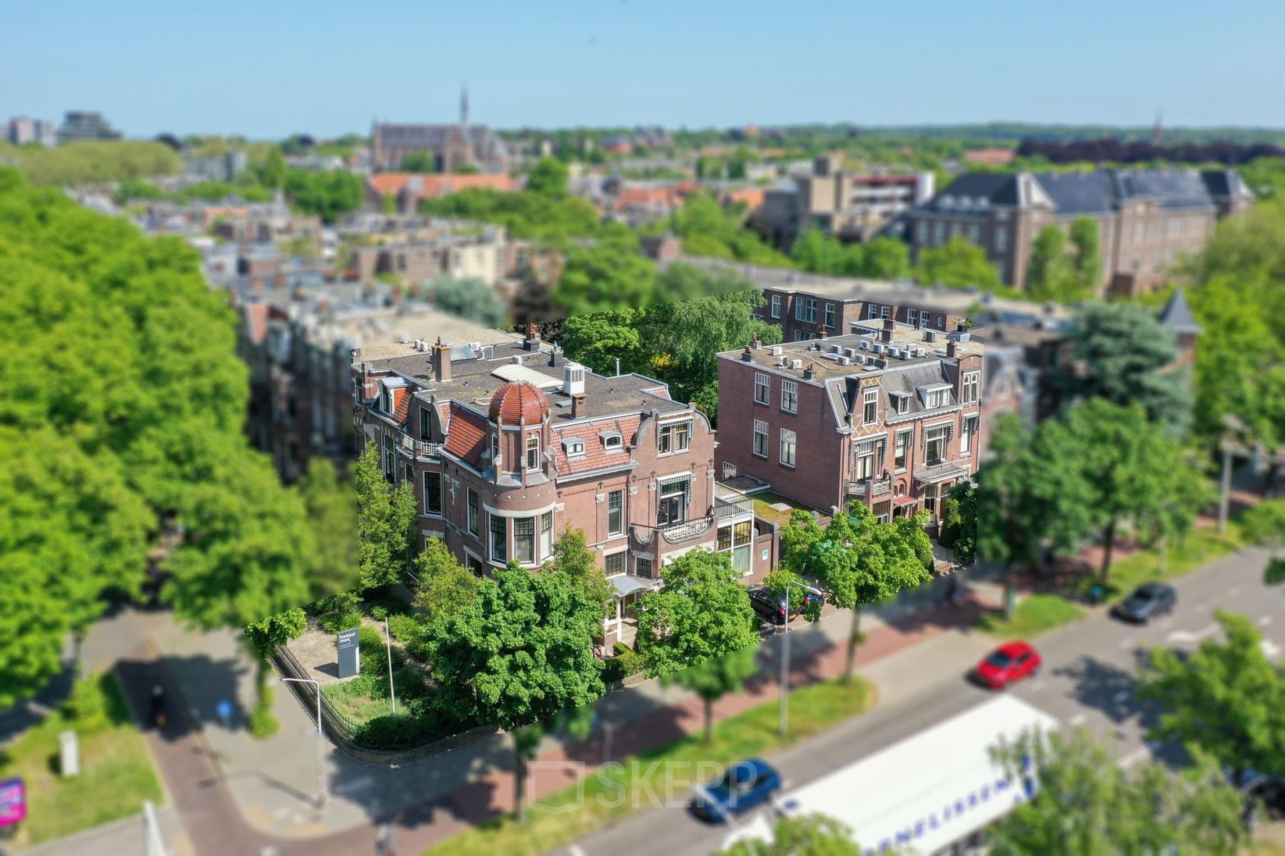 Exterior view of the office building at Oranjesingel 51, Nijmegen, surrounded by trees and cityscape. Perfect for those seeking unique office space rental in a vibrant neighborhood.