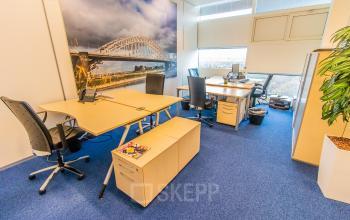 Bright office space at Jonkerbosplein 52 in Nijmegen featuring desks, chairs, and cityscape artwork, ideal for office space rental.