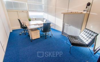 Bright office space in Nijmegen with a central desk and chairs, perfect for businesses seeking office space rental. The well-lit area offers a comfortable setting with modern furnishings.