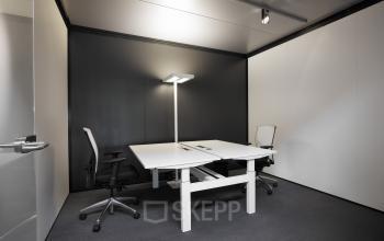 Modern and well-equipped office to rent at Koopvaardijweg 2, Oosterhout Nb, featuring a minimalist desk and ergonomic chairs.
