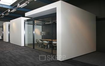 Modern office space rental at Koopvaardijweg 2, Oosterhout Nb, showcasing a glass-walled conference room with stylish furnishings.