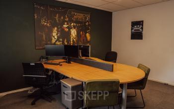 Furnished office space with a large wooden desk, computers, and chairs at Abdis van Thornstraat 74, Oosterhout Nb, ideal for office space rental.