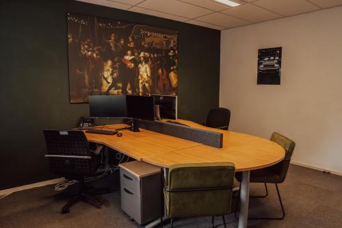 Furnished office space with a large wooden desk, computers, and chairs at Abdis van Thornstraat 74, Oosterhout Nb, ideal for office space rental.