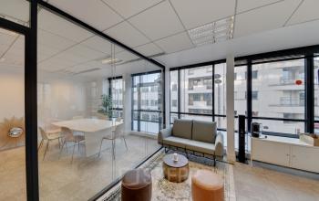 Espace de convivialité avec un canapé confortable et accès à une salle de réunion à la rue de Villiers