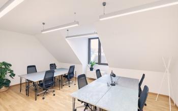 Moderner Büroraum mit mehreren Tischen und Stühlen, ideal zum Büro mieten in Am Neuen Markt 9e, Potsdam.