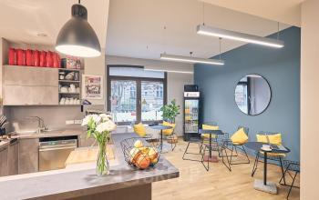 Moderner Büroraum am Neuen Markt 9e in Potsdam mit stilvollem Mobiliar, hellem Holzfußboden und gemütlichen Sitzgelegenheiten, ideal für kreatives Arbeiten.