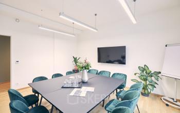 Geräumiger Konferenzraum in Am Neuen Markt 9e, Potsdam mit modernem Tisch und grün gepolsterten Stühlen, TV-Bildschirm an der Wand. Ideal zum Büroraum mieten.