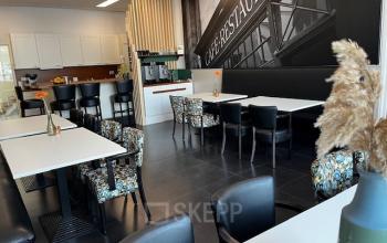 Chic office space rental with stylish black-and-white wall art and floral-patterned chairs at Leeghwaterstraat 25, Reeuwijk. Ideal for open floor plan office to rent.