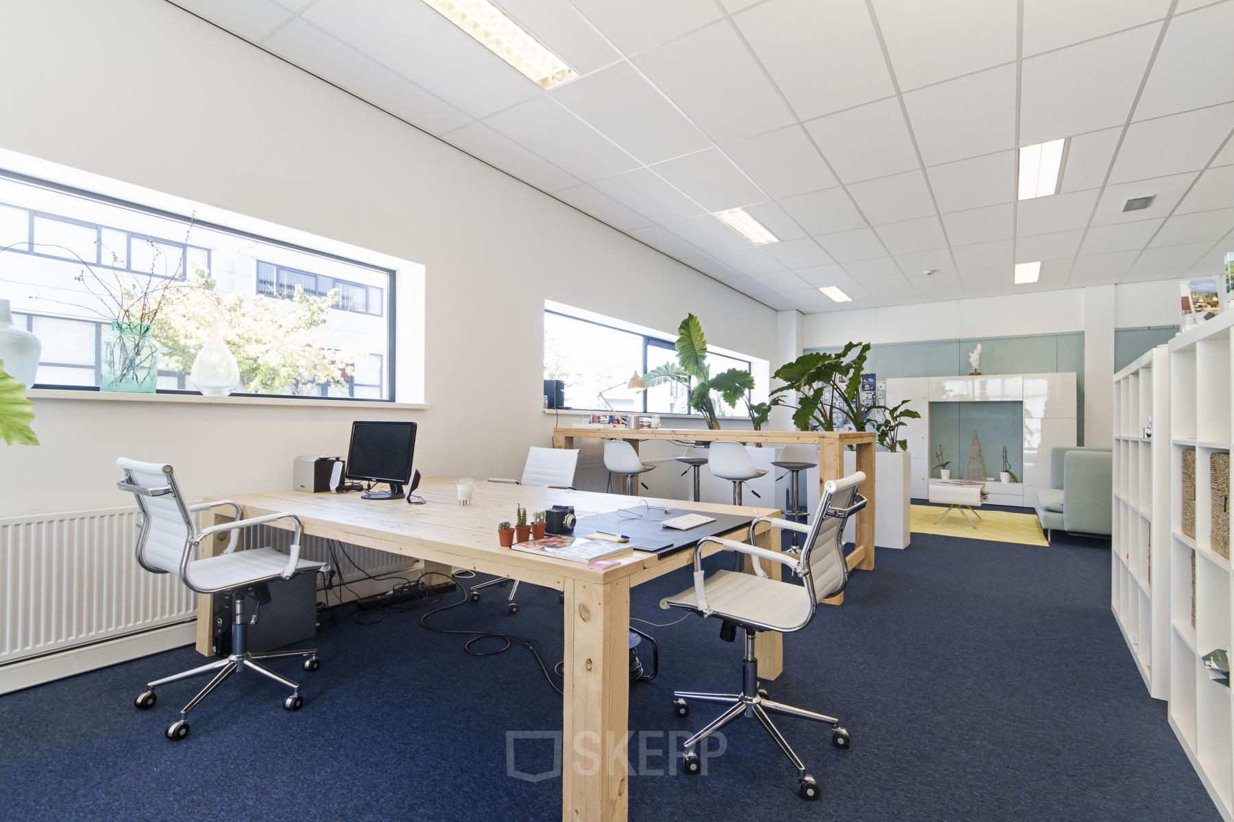 Bright office space at Leeghwaterstraat 25, Reeuwijk, featuring wooden desks, ergonomic chairs, and large windows. Ideal for rent office space seekers.