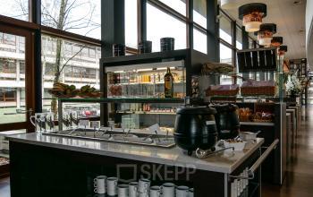 Spacious and well-lit pantry at the office located at Ericssonstraat 2, Rijen, featuring a central island with kitchenware and food items displayed.