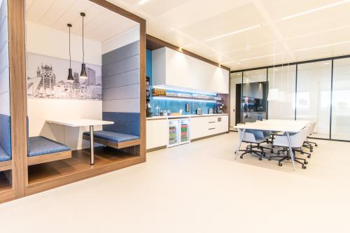 Modern office space rental at Einsteinlaan 28, Rijswijk features sleek workspaces with a stylish meeting area, built-in booths, and contemporary furnishings. Ideal for collaborative work environments.
