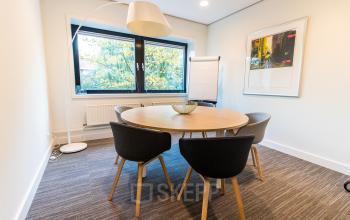 Bright office space with a round table and four chairs, offering a modern and cozy setting ideal for meetings. Perfect for office space rental at Laan van Vredenoord 33, Rijswijk.