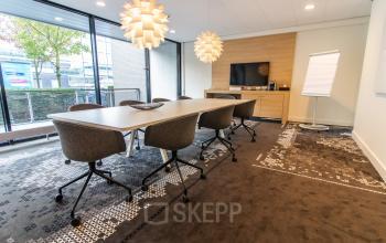 Modern conference room with stylish lighting and a large table, ideal for office space rental at Laan van Vredenoord 33, Rijswijk.