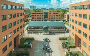 Exterior view of the office buildings on Lange Kleiweg 50-62 in Rijswijk, highlighting a spacious courtyard and surrounding structures, ideal for office space rental.
