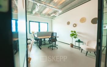 A modern office space featuring a sleek design with workstations and ergonomic chairs under a ceiling with exposed ductwork, located in Lange Kleiweg, Rijswijk. Ideal for office space rental.